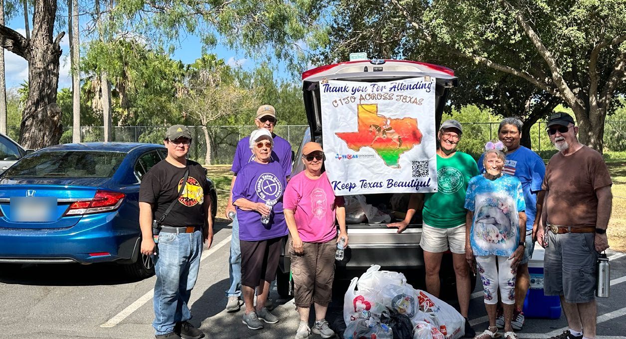 Volunteers around an open hatchback holding a CITO Across Texas thank-you banner that reads Keep Texas Beautiful, with filled bags in the cargo area